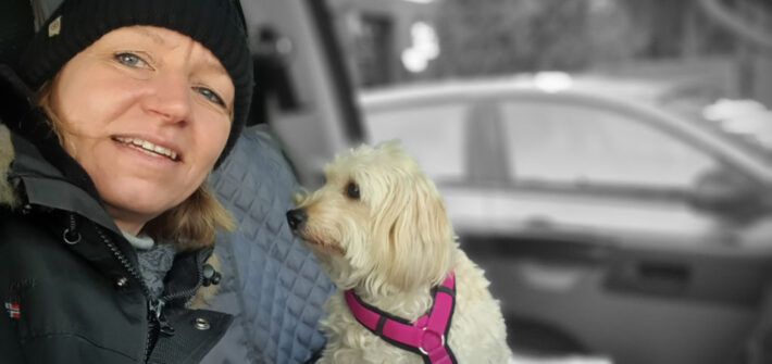 Jungfernfahrt mit Hindernissen. Selfie von Andrea und Polly in der Fahrerkabine von Bulli Murphy . Polly schaut mal wieder zur Seite und nicht in die Kamera. Sie hat ein rosa Geschirr um und ist mit einer Leine gesichert.